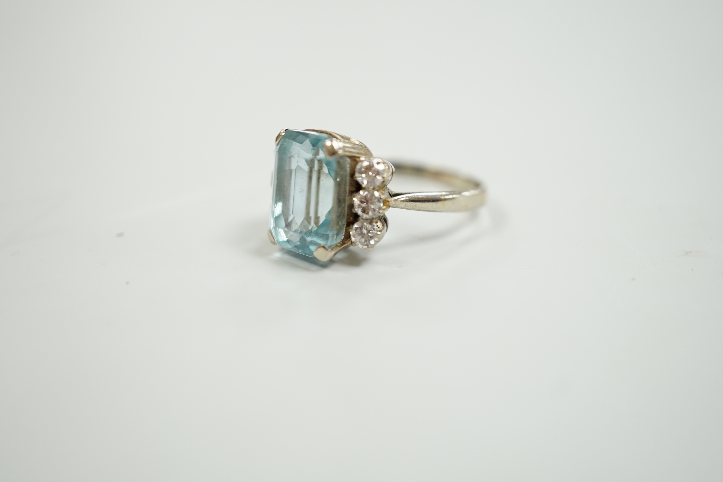 A white metal and single stone emerald cut aquamarine and six stone diamond set dress ring, size P/Q, gross weight 4.2 grams.